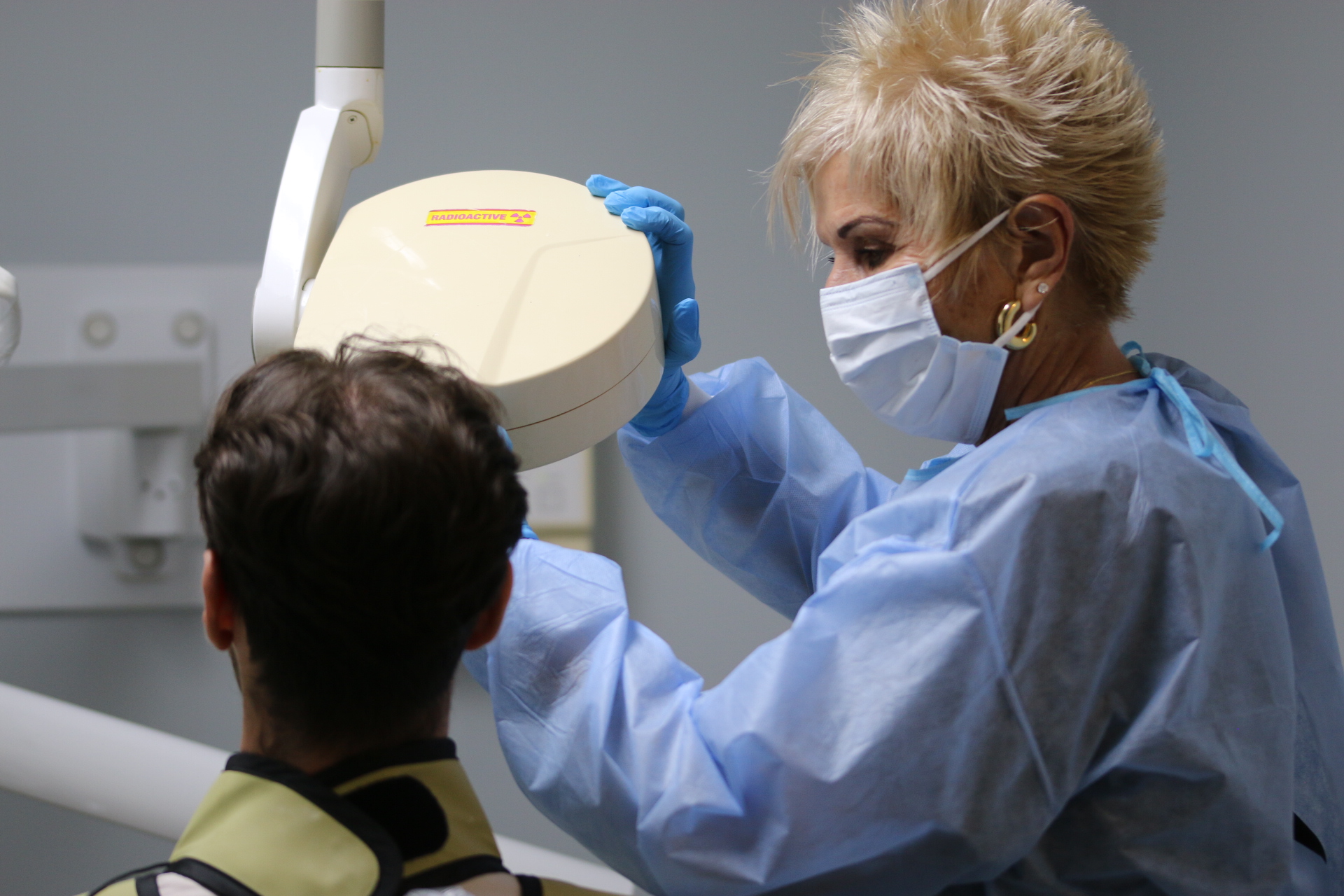 Dental team member positioning imaging equipment for a patient